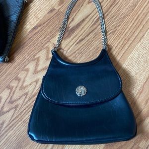 Black handbag with decorative gold snap closure.